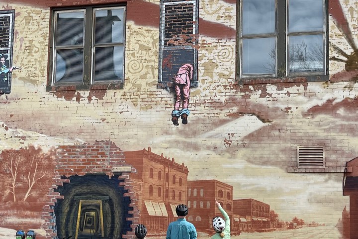 a person riding a bicycle in front of a brick building